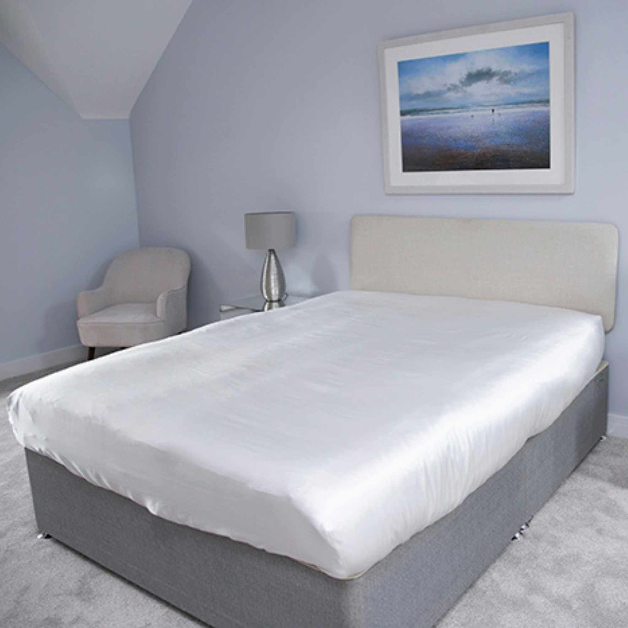 fitted silk sheet on a bed taken from a corner angle