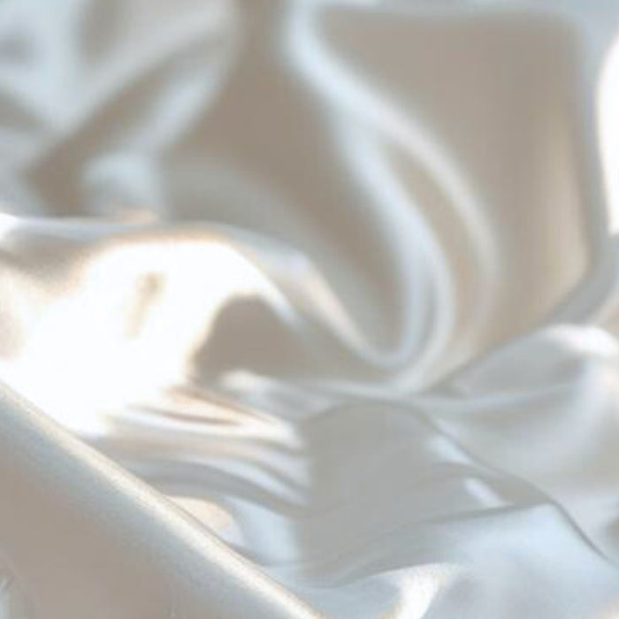 Close-up of ivory silk fabric with soft shadows