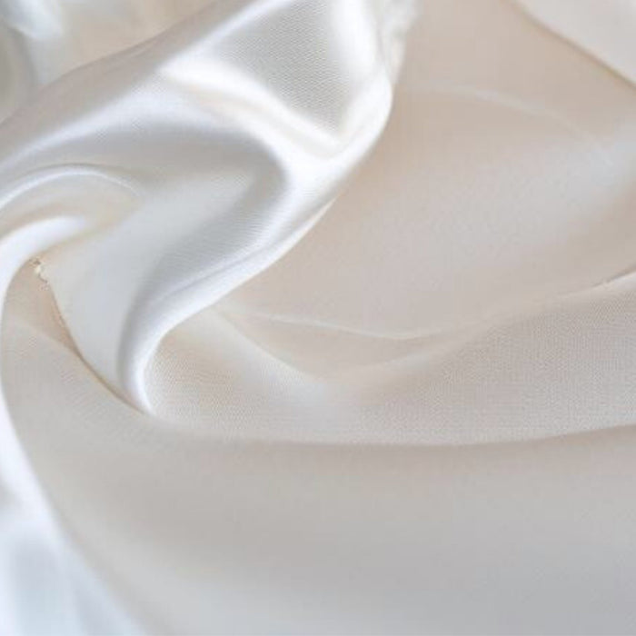 Close-up of ivory silk fabric with folds