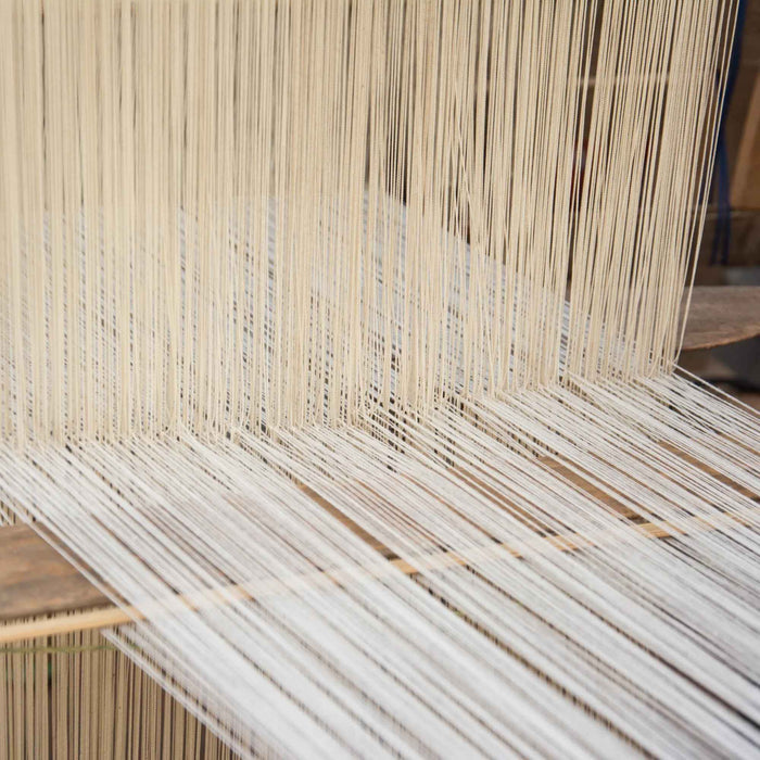 Close-up of a loom with silk threads being woven