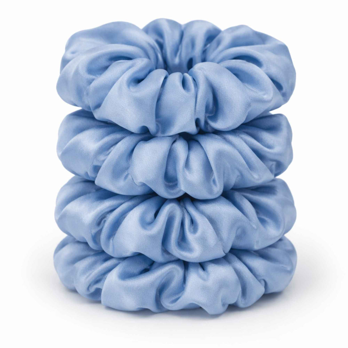 Stack of baby blue silk scrunchies on a white background