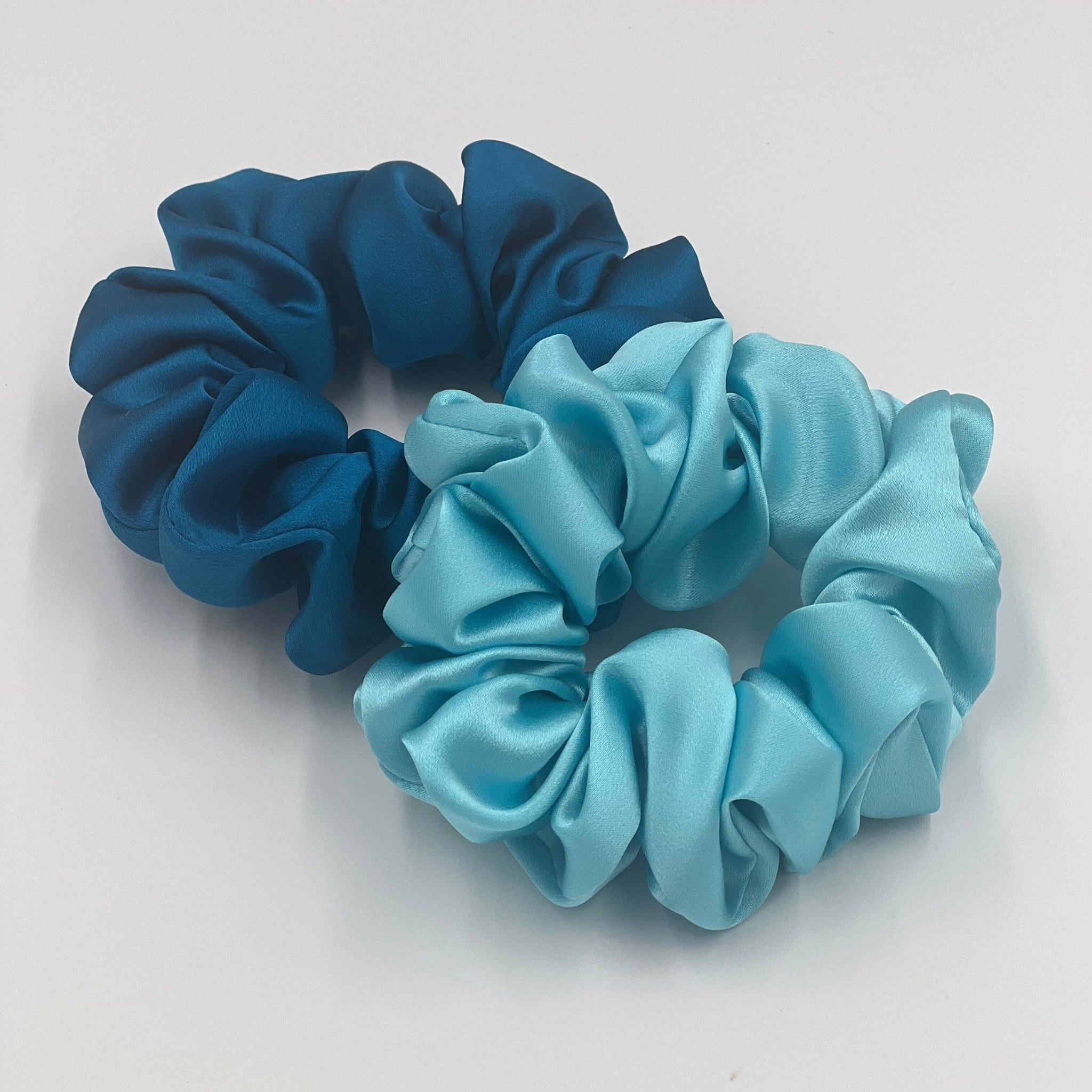 crystal teal scrunchie underneath a robins egg blue scrunchie