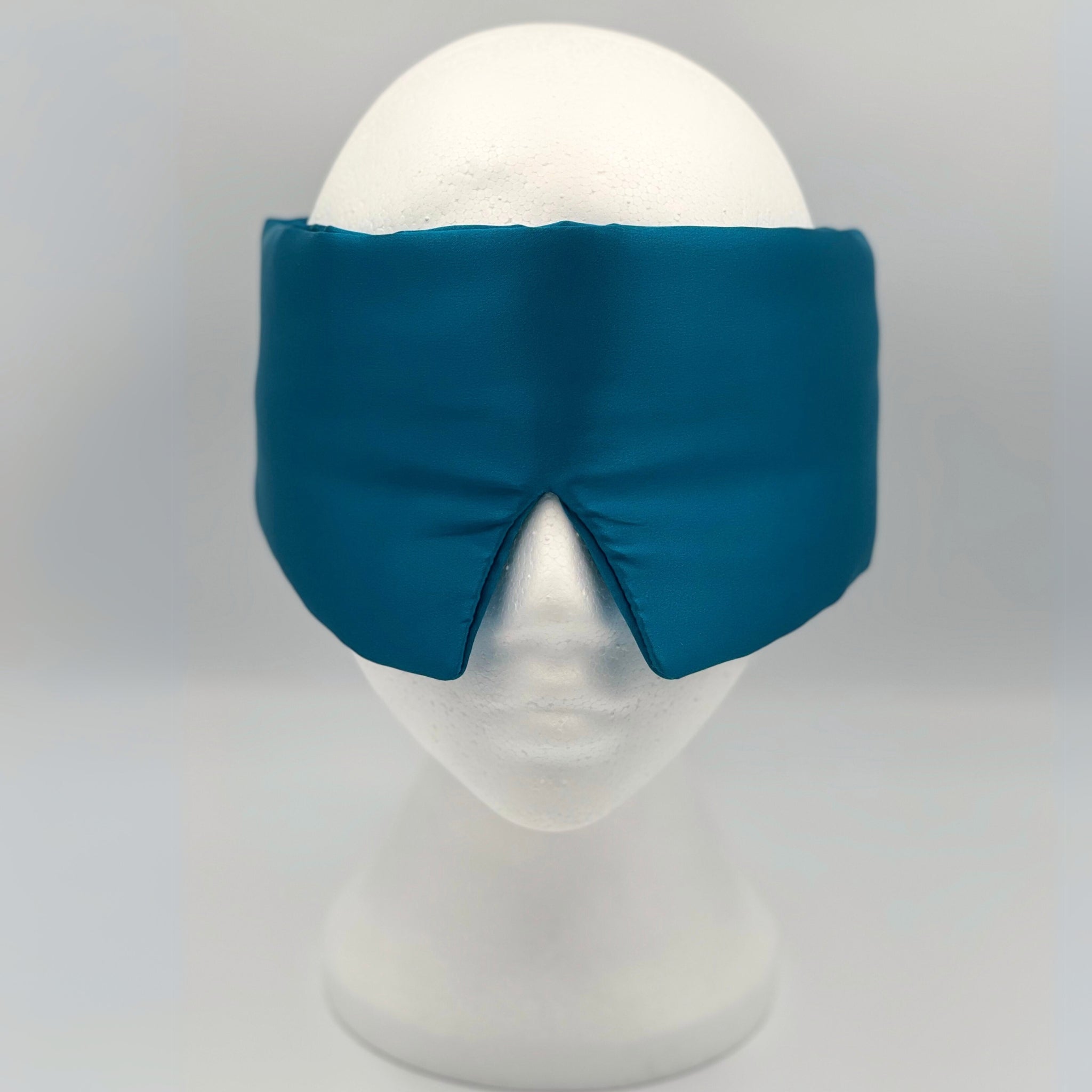 teal silk eye mask on a white mannequin head