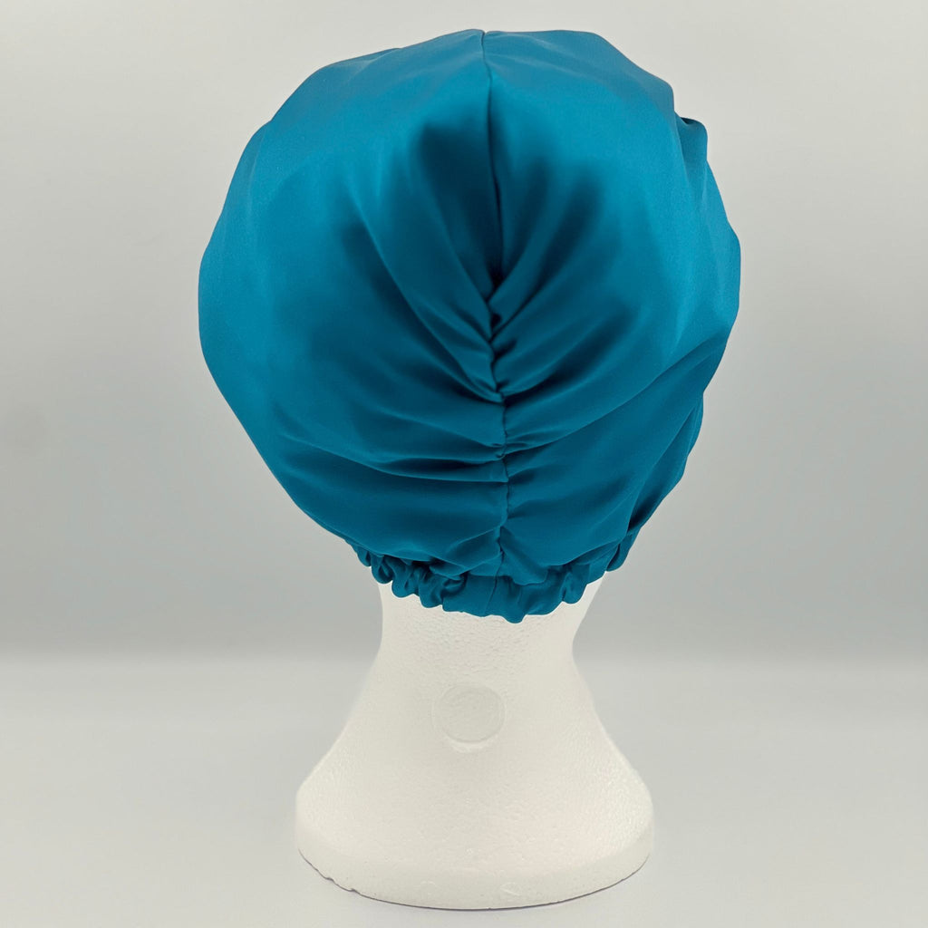 Back view of a teal silk bonnet on a mannequin