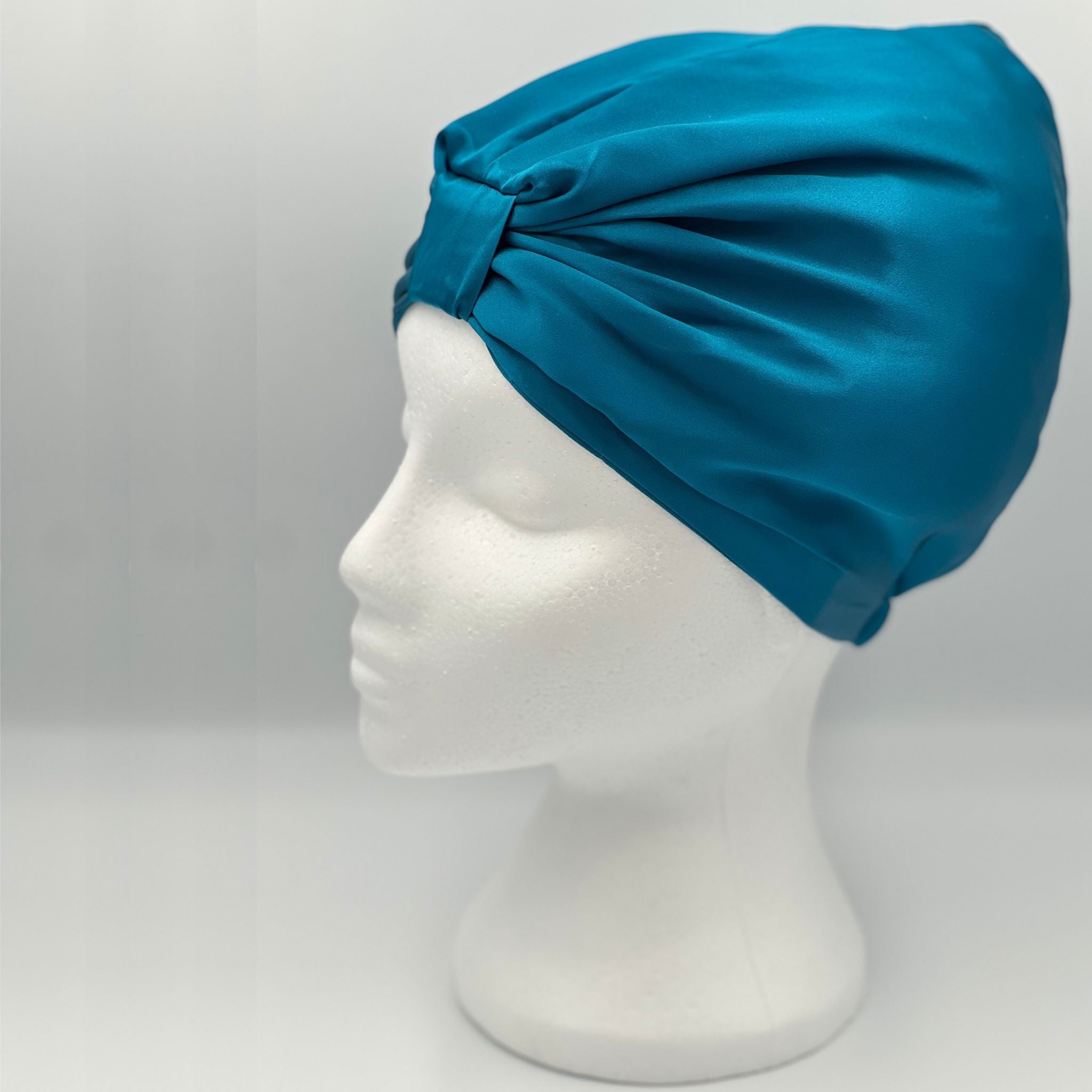 Side view of a teal bonnet on a mannequin