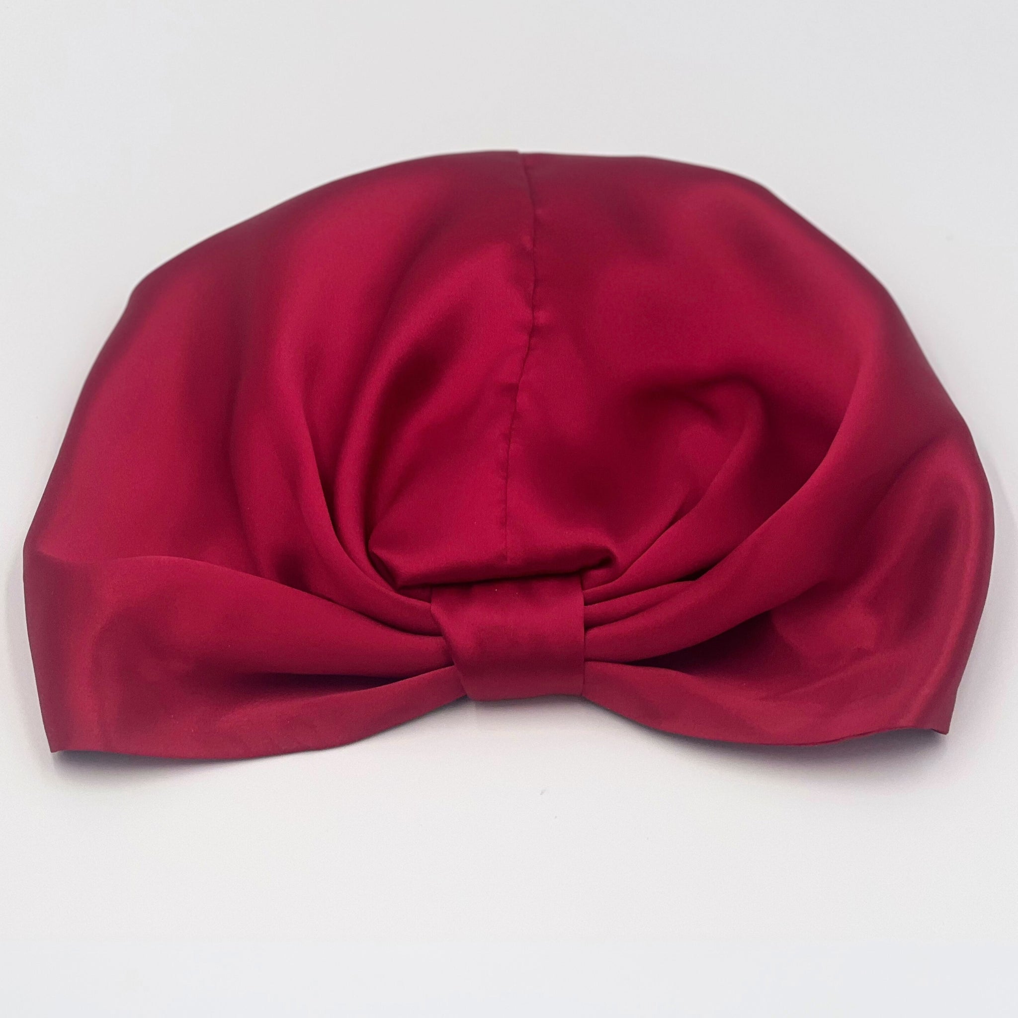 red, reversible silk bonnet lying flat