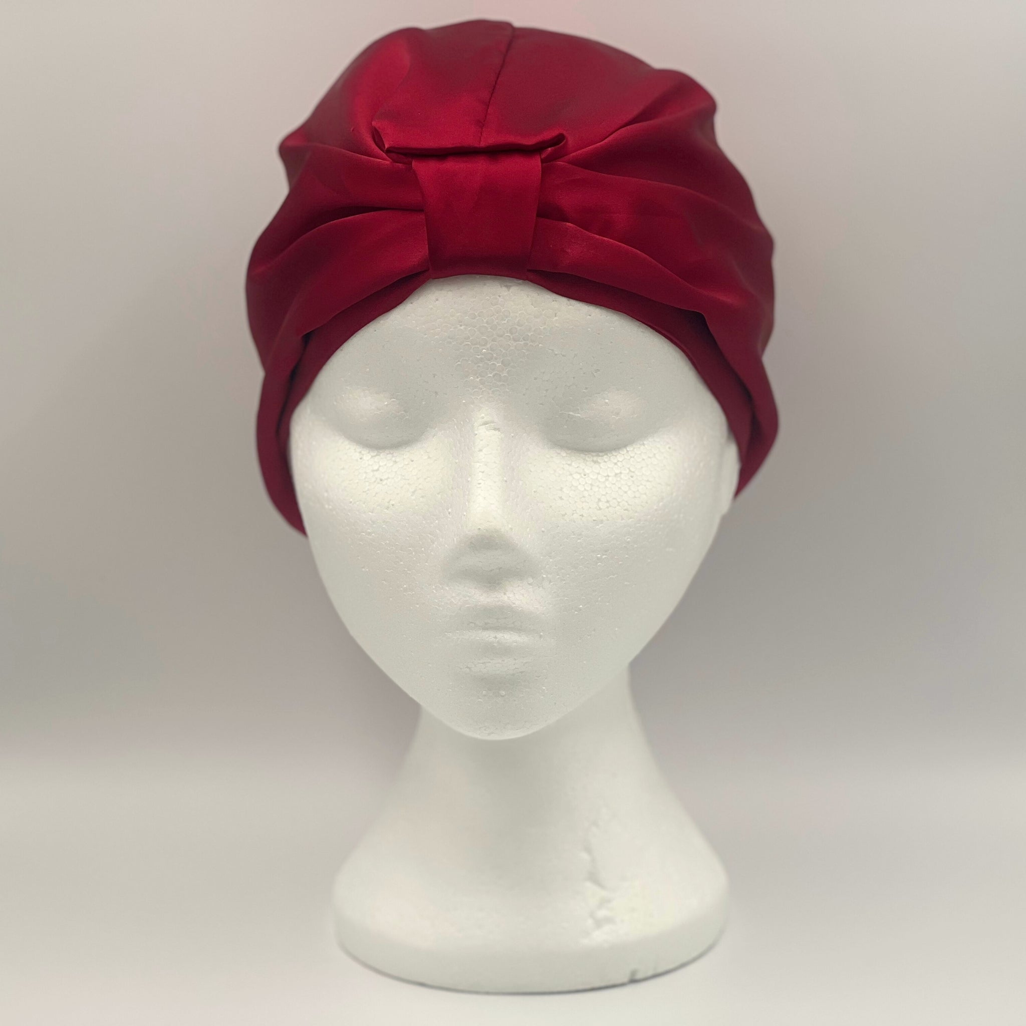 red silk bonnet on a mannequin head