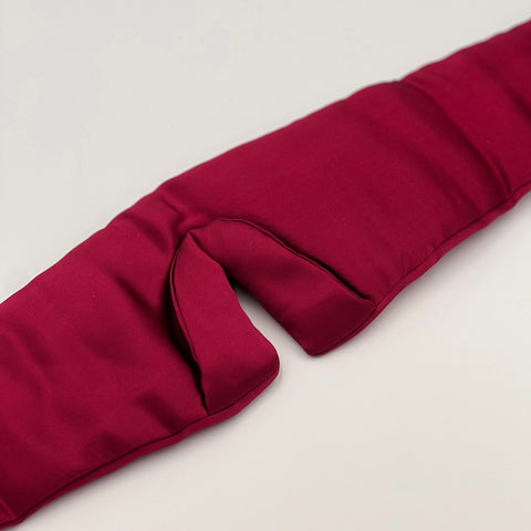 Close up of the padded nose area on a wine red silk eye mask