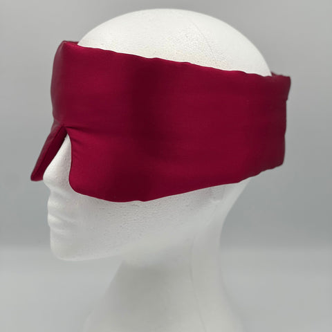 Side view of wine red silk eye mask on a mannequin